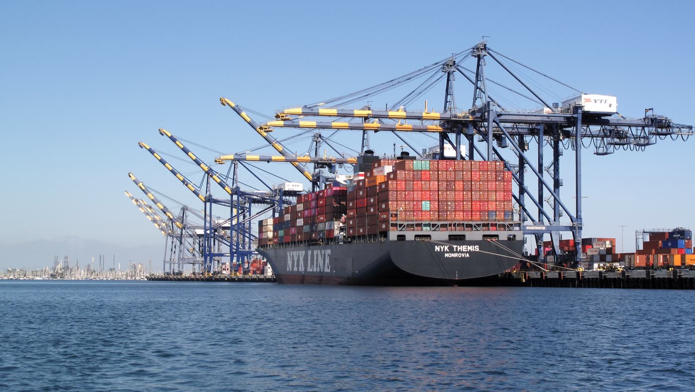 Container ship at a commercial port with stacked cargo